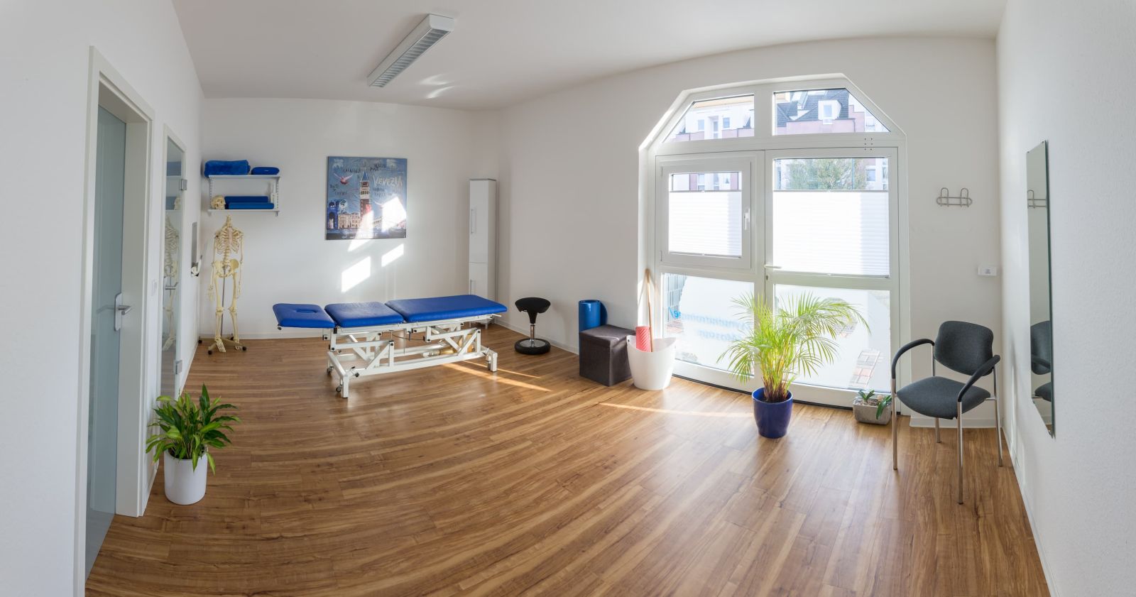 Behandlungsraum mit großem Fenster und Liege