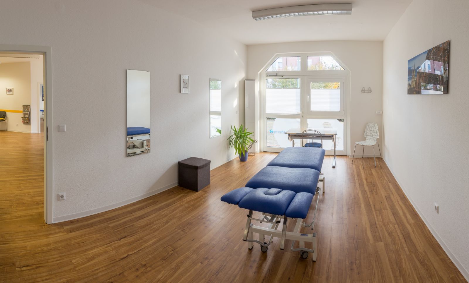 Behandlungsraum mit Therapieliege und Wandspiegel