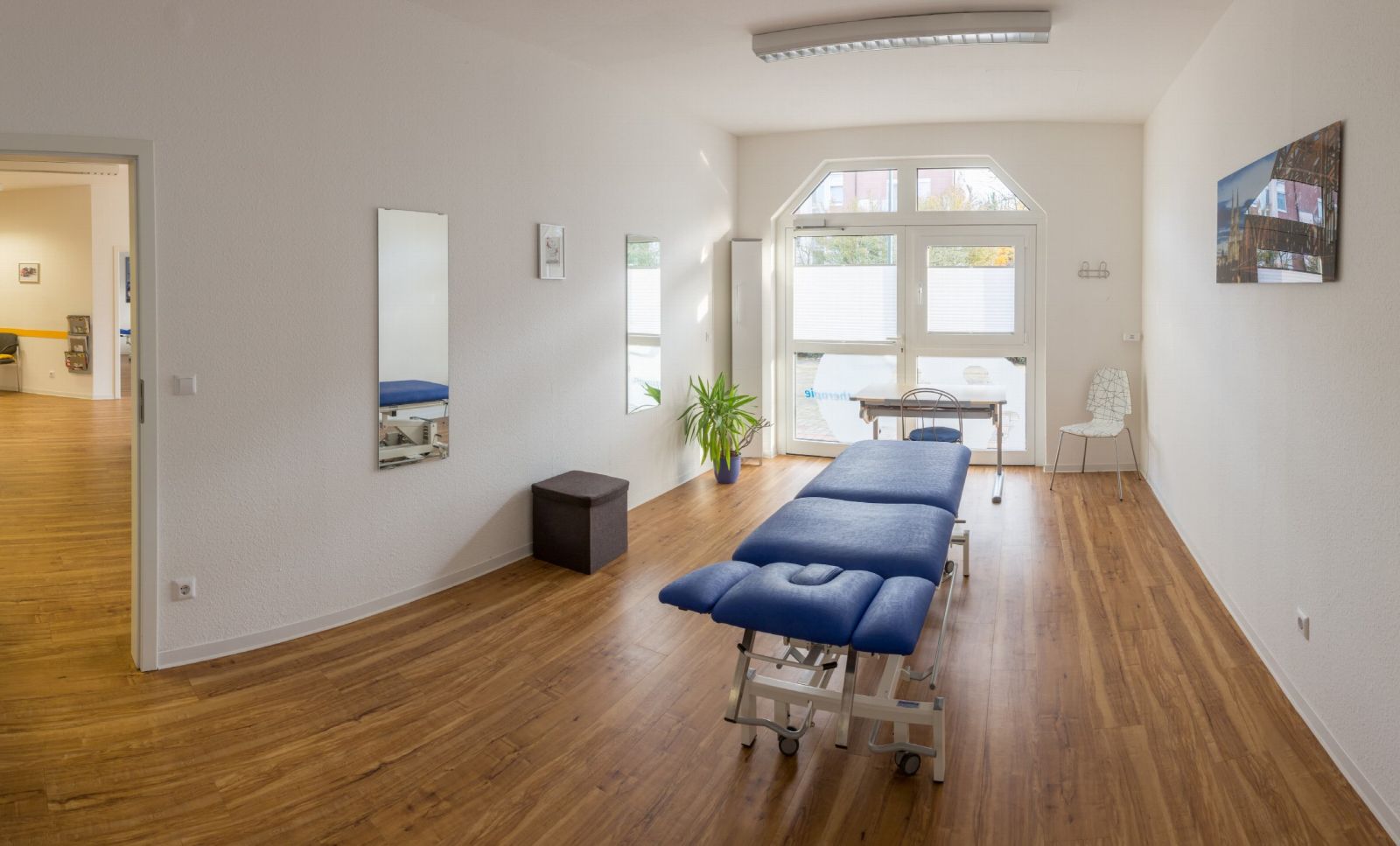 Behandlungsraum mit Therapieliege und Wandspiegel