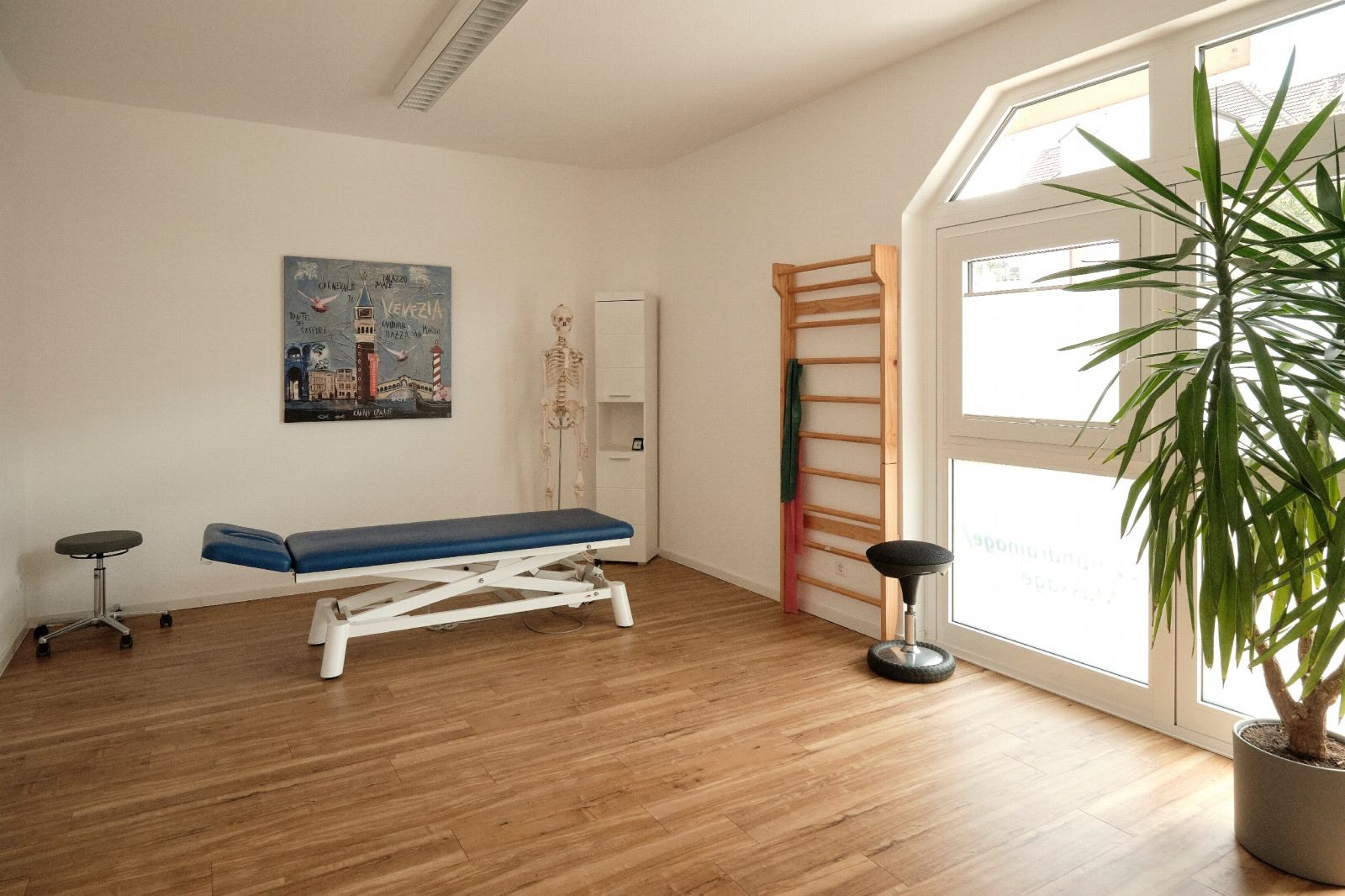 Behandlungsraum mit großem Fenster und Liege